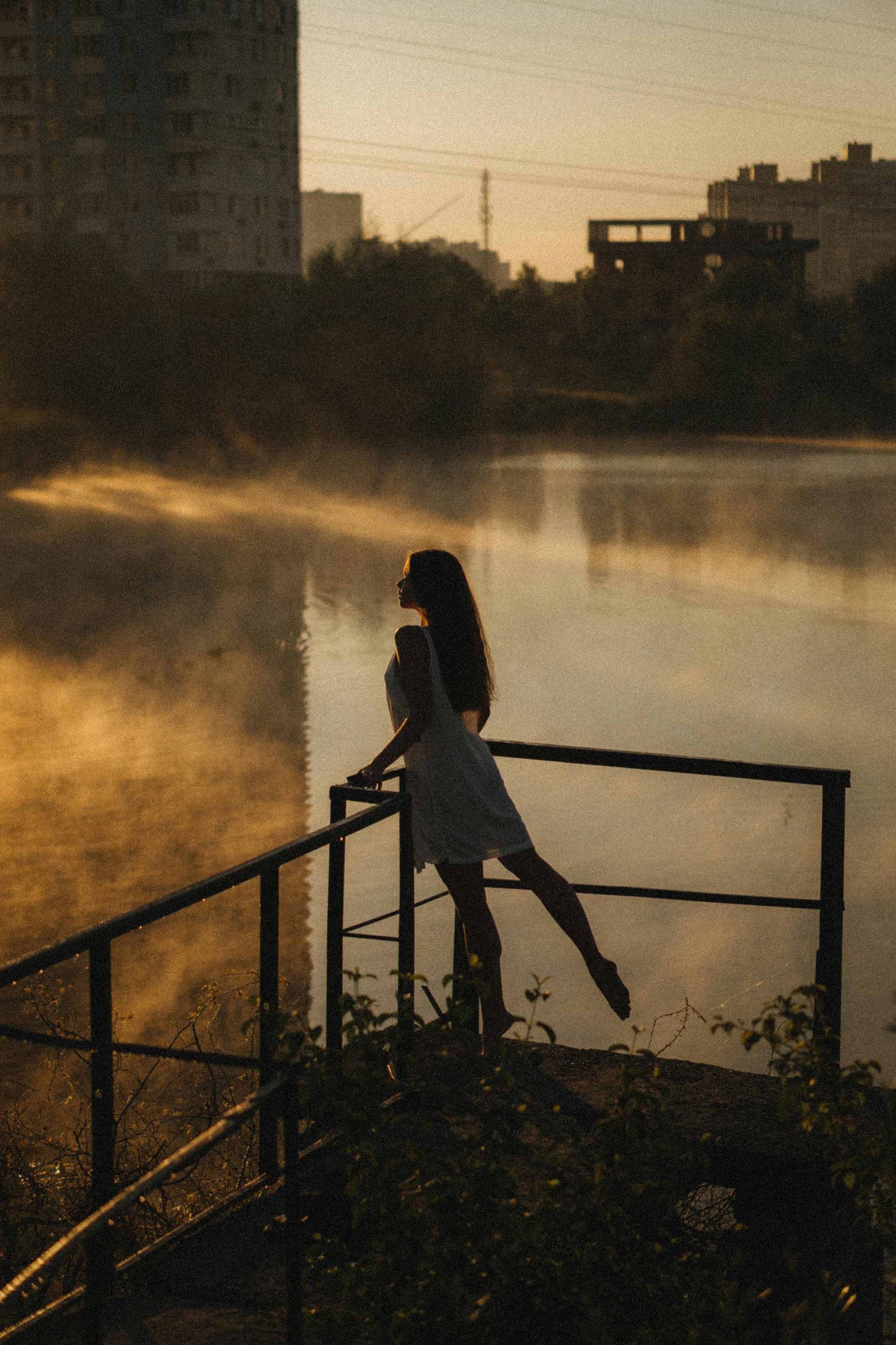 cô gái đứng bên hồ dưới ánh hoàng hôn đầy cảm xúc elle