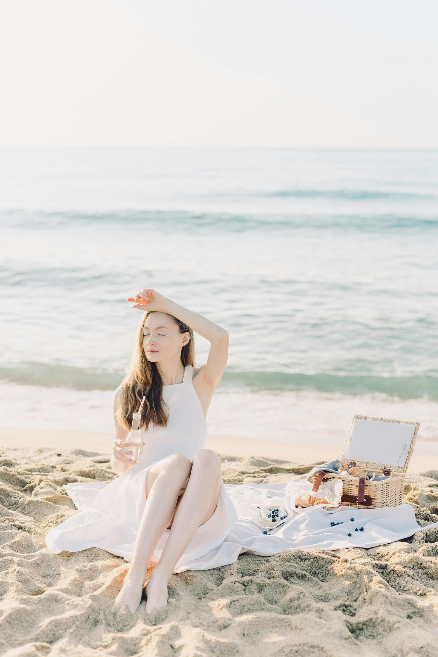 cô gái váy trắng ngồi bên bờ biển